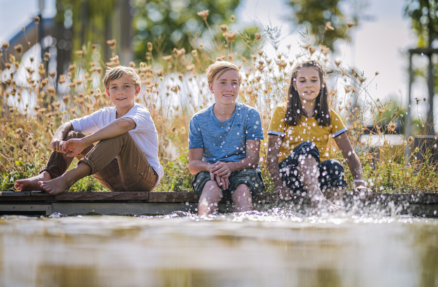 Gruppe Jugendlicher am Teich der Klima Arena